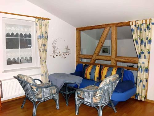 a living room with a blue couch and chairs at Apartment in Putbus II in Putbus