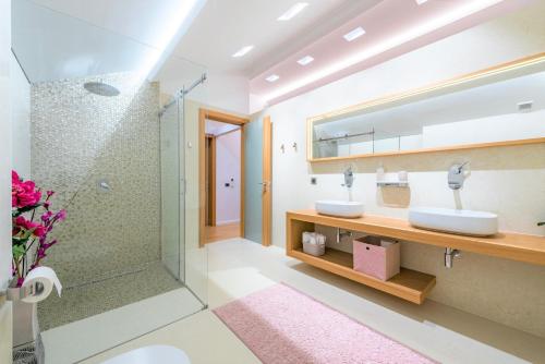 a bathroom with two sinks and a shower at Dazzling Lozica Villa 5 Bedrooms Villa Pasija Steam Room & Private Plateau Beach in Dubrovnik