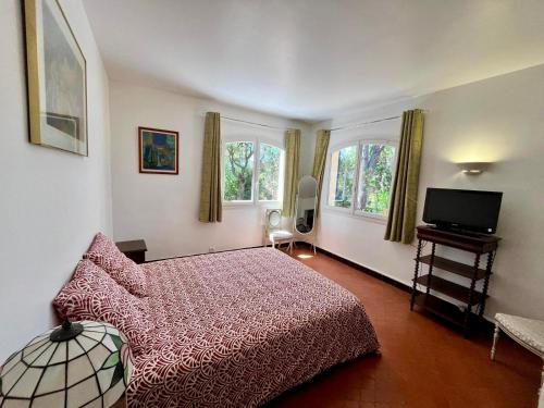 - une chambre avec un lit rouge et deux fenêtres dans l'établissement L'Esbadaia, à Saint-Raphaël