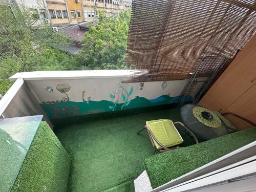 a balcony with a table and a chair on it at Ira's Square Apartment with Free Parking in Skopje