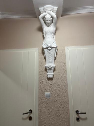 a statue of a woman hanging on a wall at Ira's Square Apartment with Free Parking in Skopje