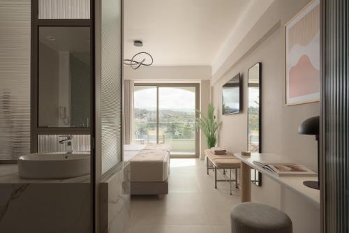 a bathroom with a sink and a mirror and a tub at Creta Star Hotel - Adults Only in Skaleta