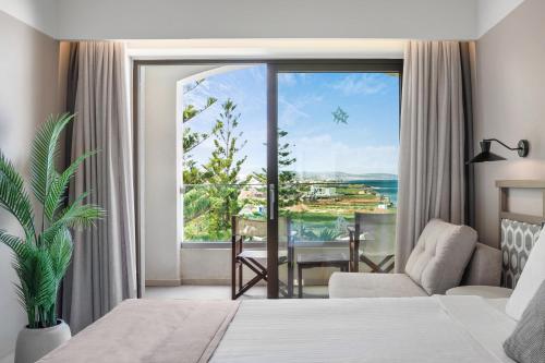 a hotel room with a bed and a large window at Creta Star Hotel - Adults Only in Skaleta