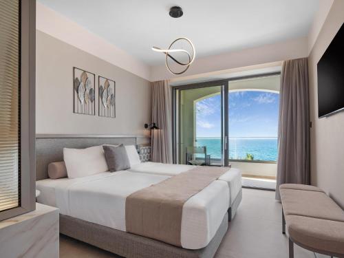a bedroom with a bed and a large window at Creta Star Hotel - Adults Only in Skaleta