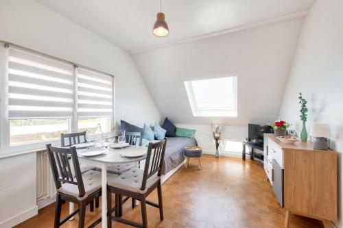 a living room with a table and chairs and a couch at Vue mer - 100m de la plage - 4 adultes 1 enfants in Plounéour-Trez
