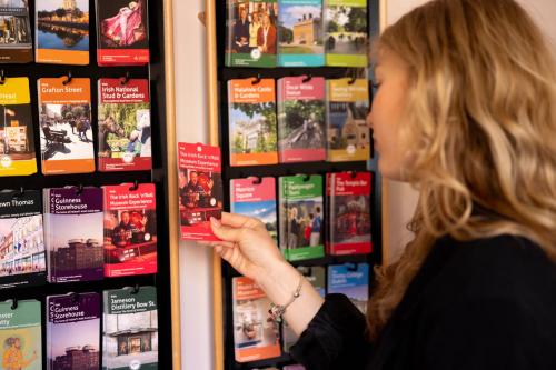 a woman is looking at a display of books at The Camden Street Hotel in Dublin