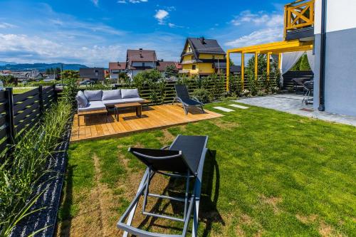 a backyard with a couch and a table and chairs at Czorsztyn- Kluszkowce Lake & Ski in Kluszkowce