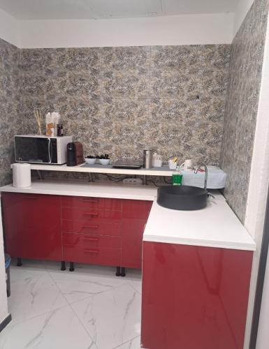a kitchen with red cabinets and a white counter top at La rosa dei pepoli in Castiglione dei Pepoli
