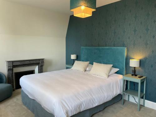 a bedroom with a large white bed with a blue wall at Le Parc Maison d'hotes de Charme in Provins