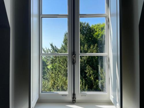 an open window with a view of trees at Le Parc Maison d'hotes de Charme in Provins
