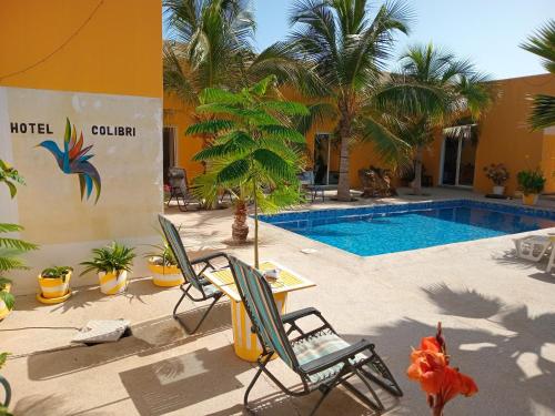 a resort with a pool and chairs and palm trees at Hôtel Colibri Lac Rose in Niaga