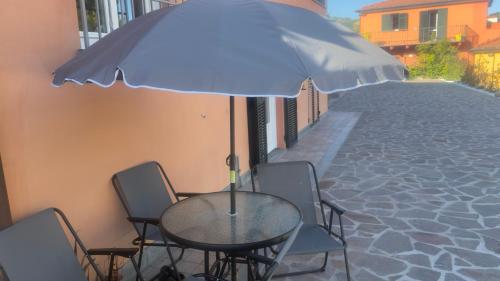 a table with chairs and an umbrella on a street at Vlletta da Amare in Imperia