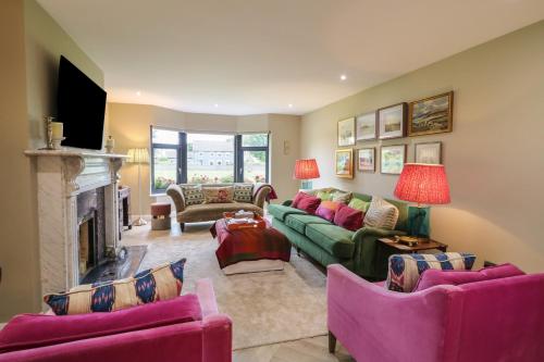 a living room with couches and a fireplace at Clarmes House in Limavady