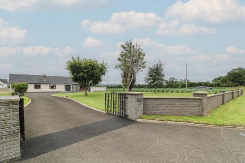 a driveway with a fence and a house at Clarmes House in Limavady