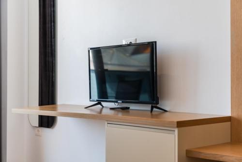 Una televisión o centro de entretenimiento en Hotel Kompleks Joni