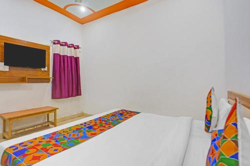 a bedroom with a bed with a colorful blanket at FabExpress Yadhuvanshi Dhaam- 900m from Prem Mandir and Iskcon Temple in Vrindāvan