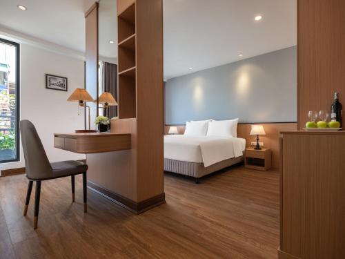 a hotel room with a bed and a desk and a desk at Minasi Grand Hotel in Hanoi