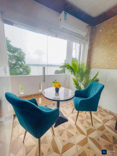 a room with a table and chairs and a large window at The Ghat House in Varanasi