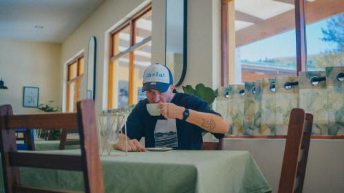 a man sitting at a table with a tattoo on his arm at Gooderson Drakensberg Gardens Golf & Spa Resort in Drakensberg Garden