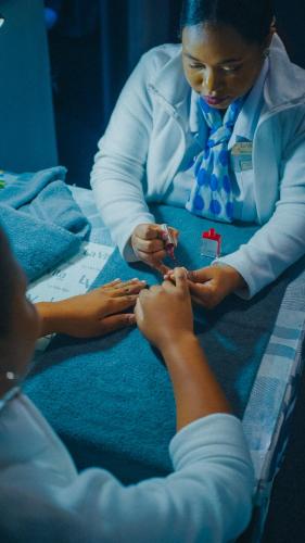 a woman in a hospital room fixing a persons nails at Gooderson Drakensberg Gardens Golf & Spa Resort in Drakensberg Garden
