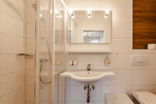 a white bathroom with a sink and a shower at Glautschhof in Weissensee