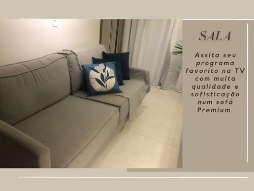 a living room with a couch and a sign that reads saliva assistayan program program at Apto Executivo Confortável in Teófilo Otoni