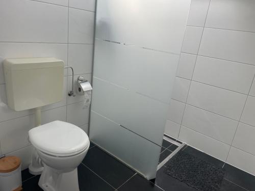 a bathroom with a white toilet in a stall at Helle Ferienwohnung mit Balkon in Itzehoe