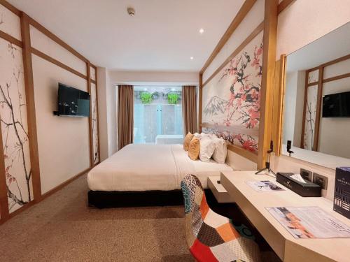 a hotel room with a bed and a desk at Verse Luxe Hotel Wahid Hasyim in Jakarta
