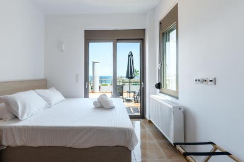 a bedroom with a bed and a large window at Kalamaki Del Mar in Chania