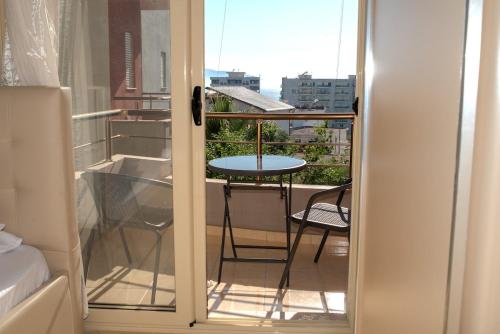 a room with a view of a balcony with a table at Vlora Getaway Comfort & Style in Vlorë