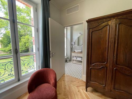 a room with a chair and a large window at Le Parc Maison d'hotes de Charme in Provins