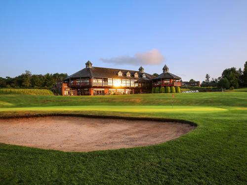 a view of a golf course with a large building at Macdonald Portal Hotel, Spa & Golf Resort in Tarporley