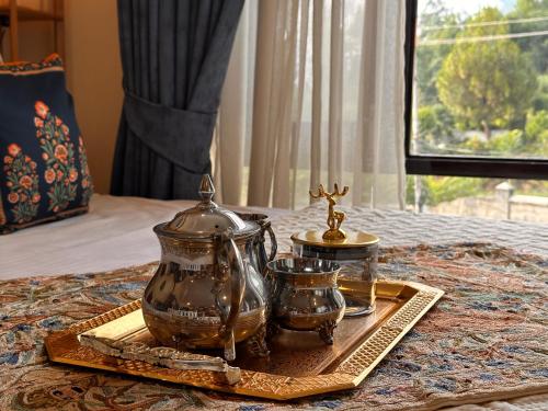 a tray with a tea set on top of a bed at Silver Woods- A Boutique Cottage in Srinagar