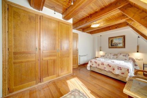 a bedroom with a bed and wooden cabinets at Arties Luxury Apartments - parking a pie de pistas Val de Ruda in Arties