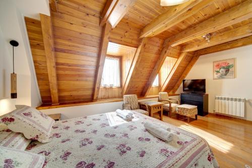 a bedroom with a bed in a room with wooden ceilings at Arties Luxury Apartments - parking a pie de pistas Val de Ruda in Arties