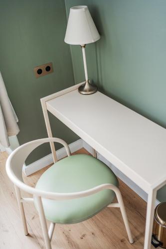 a white desk and a chair with a lamp at HOME1 - District Twelve Boutique Hostel in Vienna