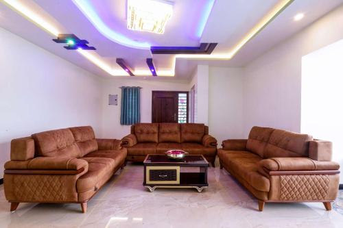 a living room with leather couches and a table at Cozy Heaven in Ooty
