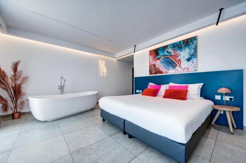 a bedroom with a large bed and a bath tub at Flamingo Hotel Malta in St Julian's