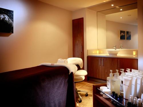 a bathroom with a tub and a sink and towels at Macdonald Portal Hotel, Spa & Golf Resort in Tarporley