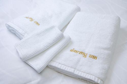 two white towels with the words healthy hit on them at Dormy Inn Express Toyohashi in Toyohashi