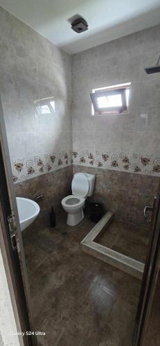 a bathroom with a toilet and a sink at ilios in K'obulet'i