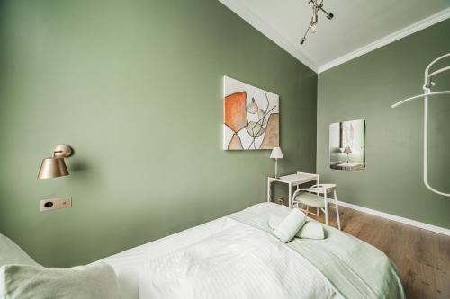 a bedroom with a bed and a desk with a lamp at HOME1 - District Twelve Boutique Hostel in Vienna