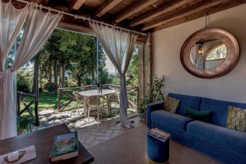 a living room with a blue couch and a table at Be Vedetta - Relais & Glamping - Adult Only in Scarlino