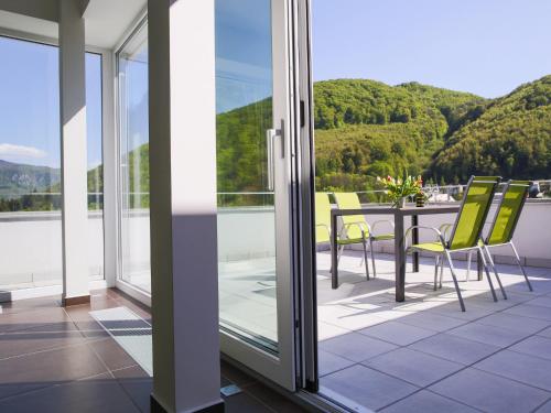 a balcony with a table and chairs and mountains at Villa Irene in Trenčianske Teplice
