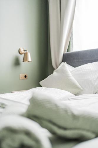 a bed with white sheets and a lamp next to a window at HOME1 - District Twelve Boutique Hostel in Vienna