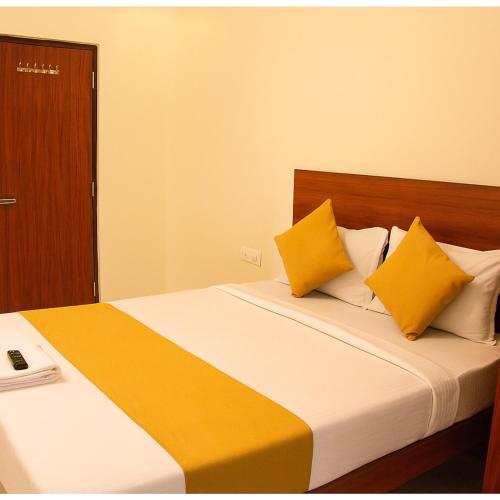 a bedroom with a bed with yellow and white pillows at Hotel Gokul Pride Near Secunderabad Railway station in Hyderabad