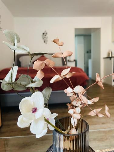 a vase with flowers in a room with a bed at Haus Erna Weitra in Weitra