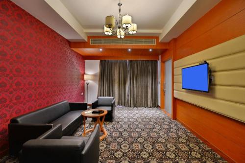a hotel room with a couch and a flat screen tv at Best Western Summerlea in Jalandhar