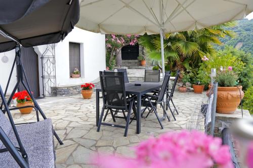 a table and chairs under an umbrella on a patio at Villa Blanca Koukourava in Makrinitsa