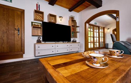 a living room with a wooden table with a flat screen tv at Villa 77 by Villas Guide in Sisak